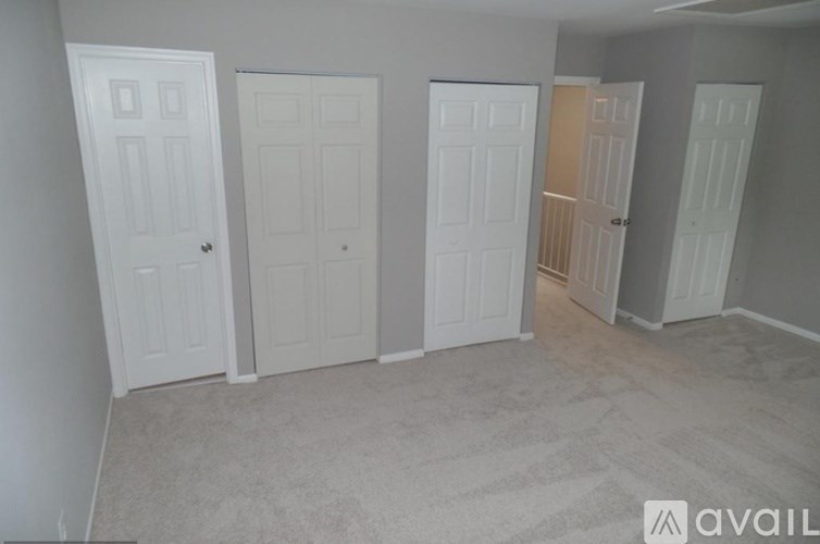 A room with four doors, three of which are closed.