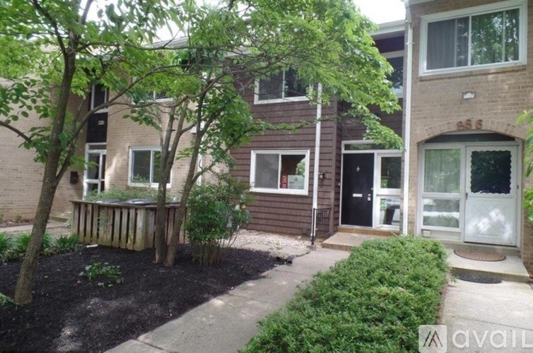 A tree in a front yard of a brick building.