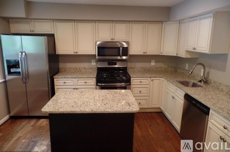A kitchen with a granite countertop and stainless steel appliances.
