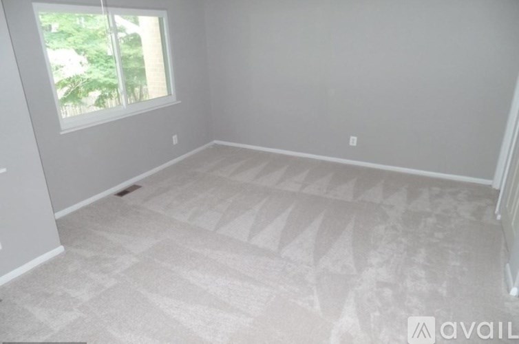 A room with a carpeted floor and a window.
