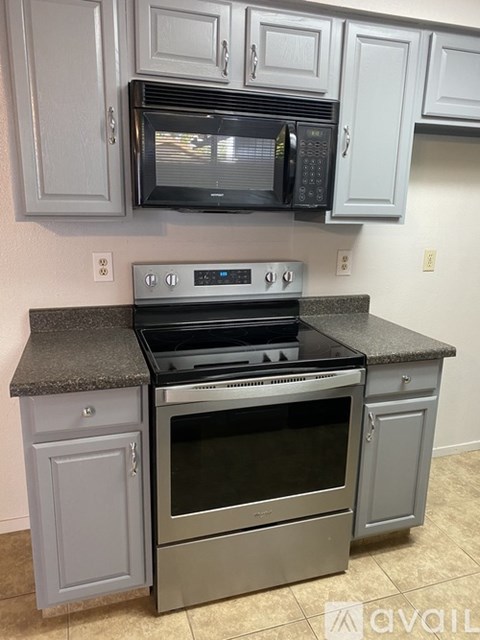 A kitchen with a black microwave above a stove.