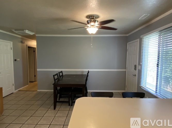 A dining room with a table and chairs.