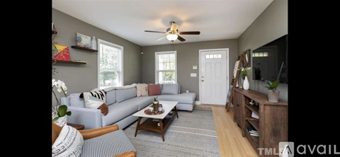A living room with a grey couch and a wooden coffee table.