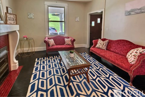 A living room with a red couch and a coffee table.