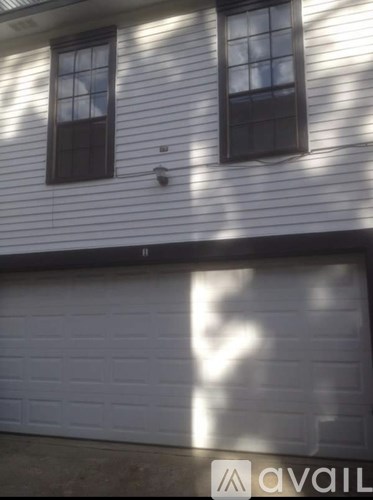 A white house with a black garage door.