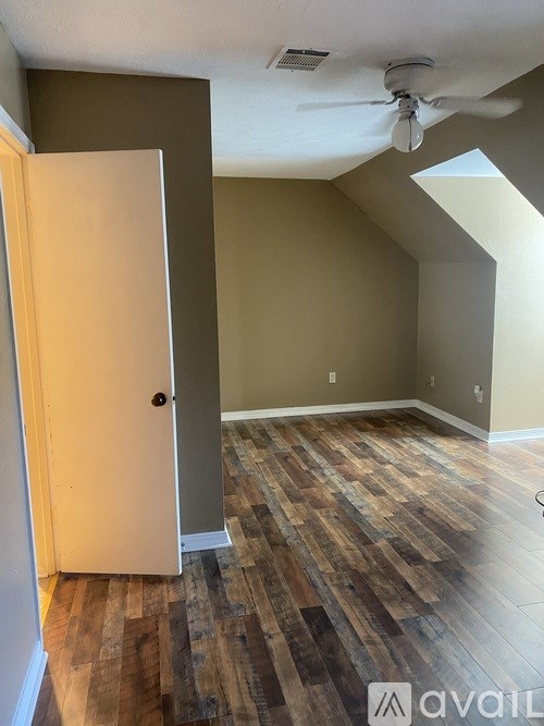 A room with a wooden floor and a ceiling fan.