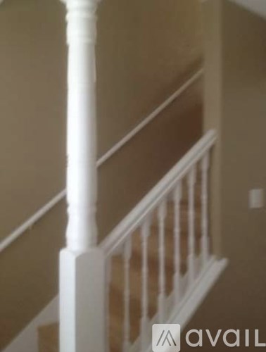A white stair railing with a beige wall in the background.