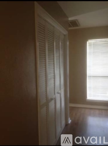 A room with a window and a closed white door.