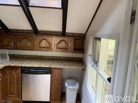 A kitchen with wooden cabinets and a dishwasher.