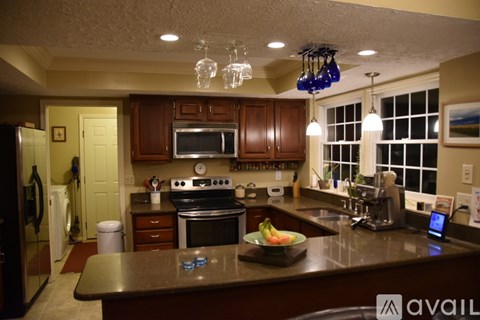 A kitchen with brown cabinets and a black stove top oven.