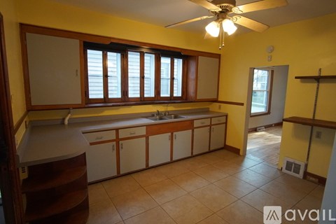 A kitchen with yellow walls and a ceiling fan.