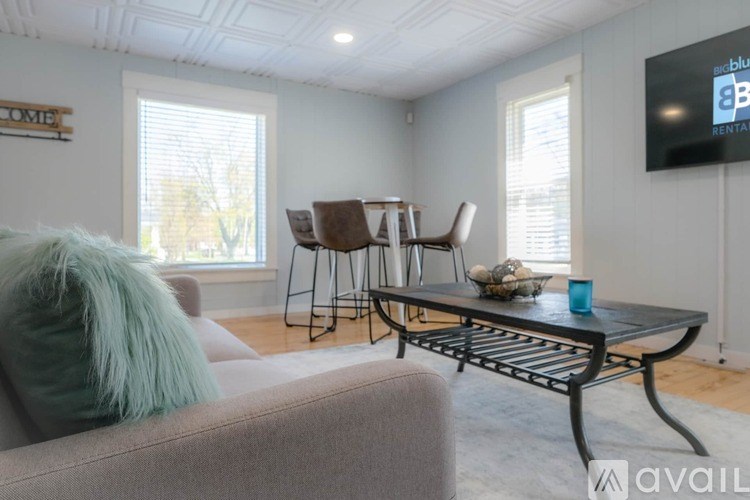 A living room with a grey couch and a black coffee table.
