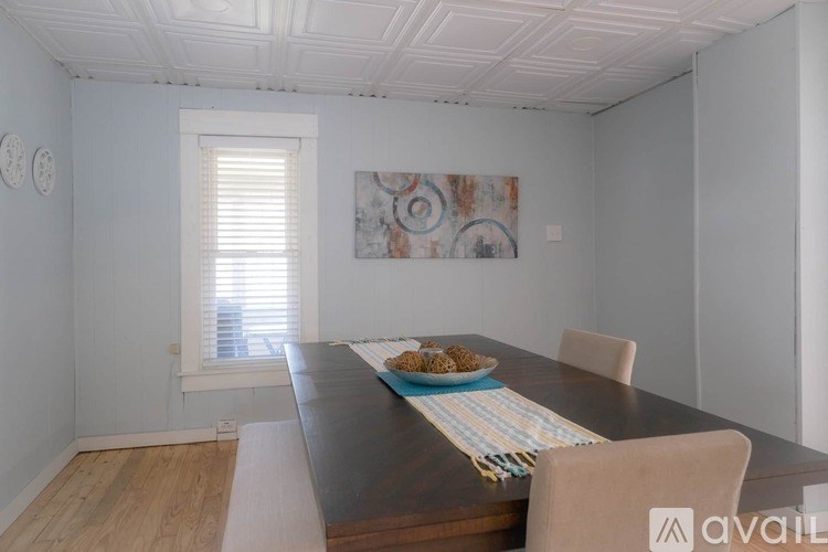 A dining room with a wooden table and chairs.
