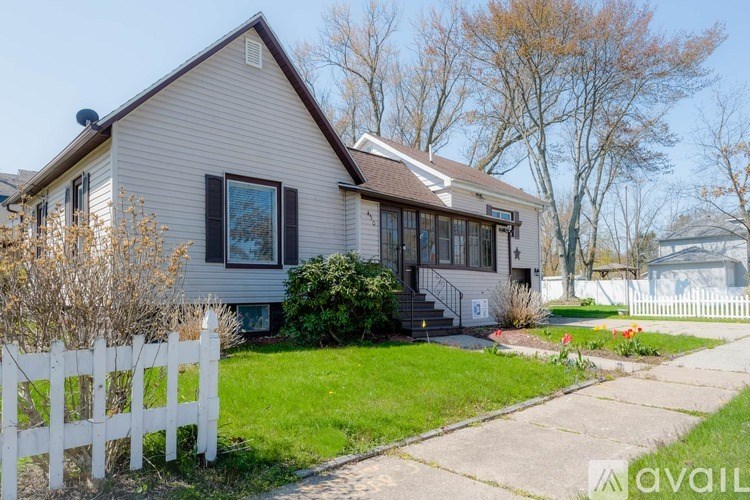A house with a white picket fence in front.