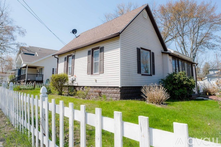 A house with a white picket fence in front.