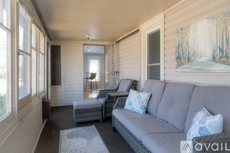 A living room with a grey couch and a painting on the wall.