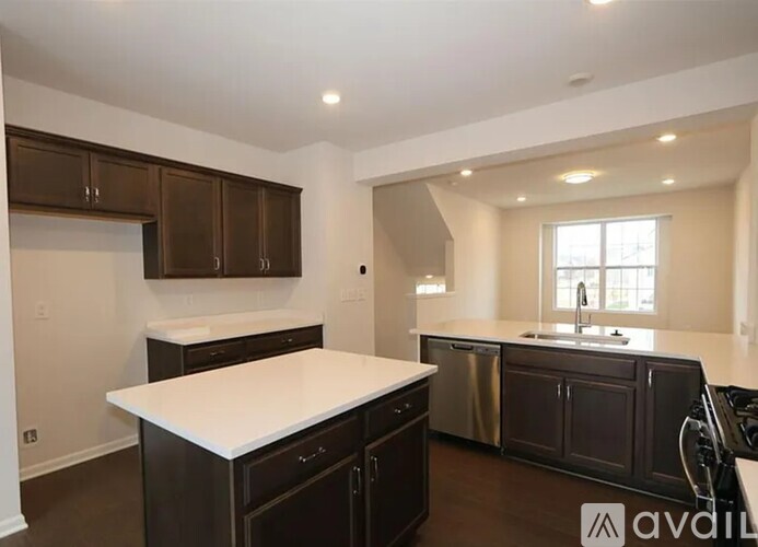 A kitchen with dark brown cabinets and a white countertop.