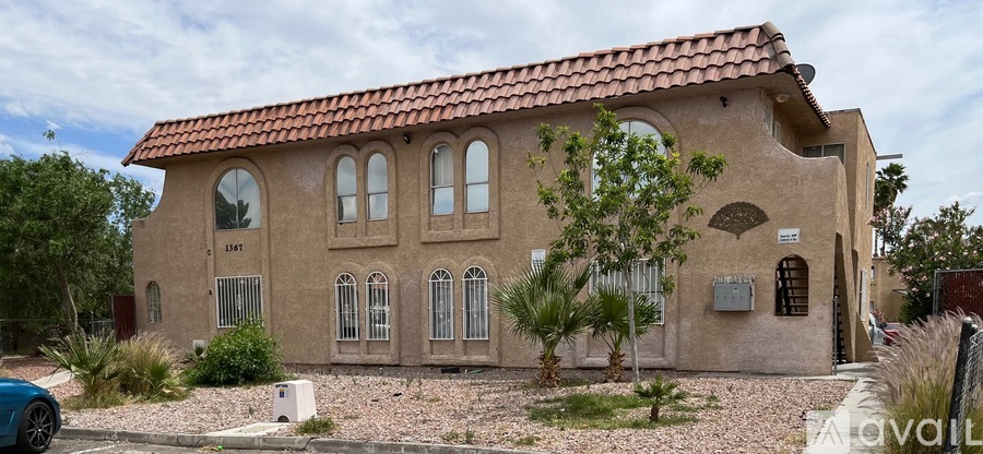 A house with a red tile roof and a sign that says "AVAILABLE" in front of it.