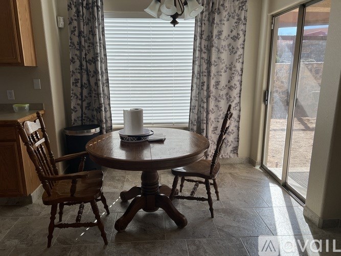 A dining room with a round wooden table and chairs.