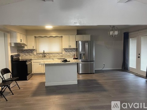 A kitchen with a black chair and a white island.