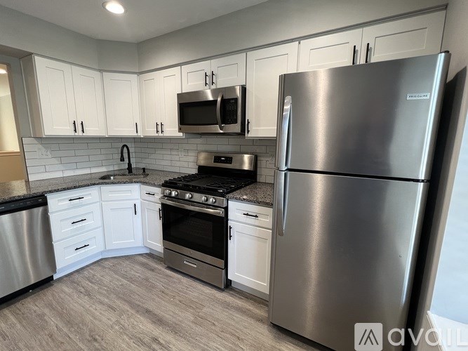 A kitchen with a stainless steel refrigerator, oven, and microwave.