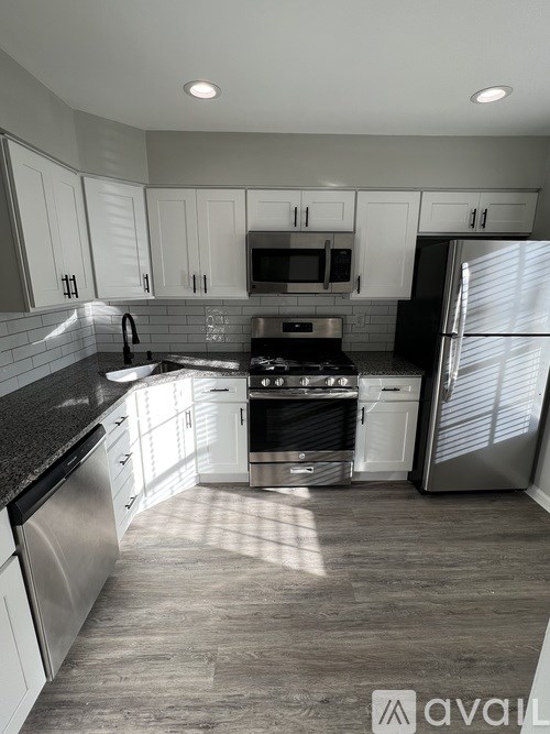 A modern kitchen with stainless steel appliances and white cabinets.