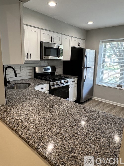 A kitchen with granite countertops and stainless steel appliances.