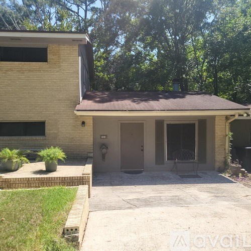 A house with a brown roof and a grey garage door.