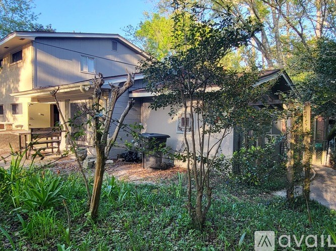 A house surrounded by greenery with a sign that says "available".