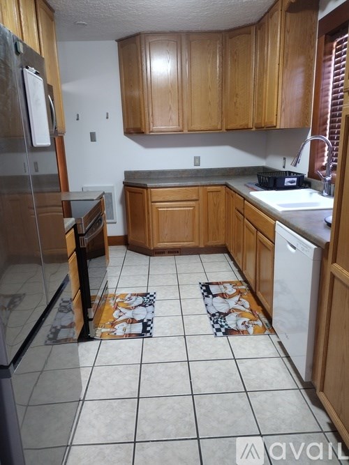 A kitchen with wooden cabinets and a white dishwasher.