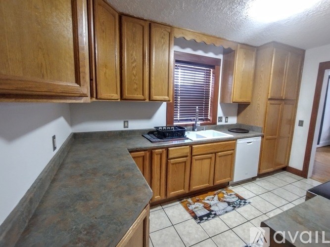 A kitchen with wooden cabinets and a granite countertop.