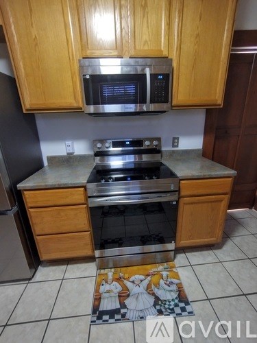 A kitchen with wooden cabinets and a tiled floor.
