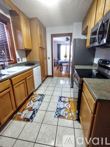 A kitchen with wooden cabinets and a tiled floor.