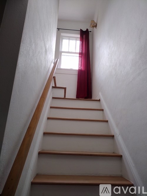 A staircase with a red curtain in the background.