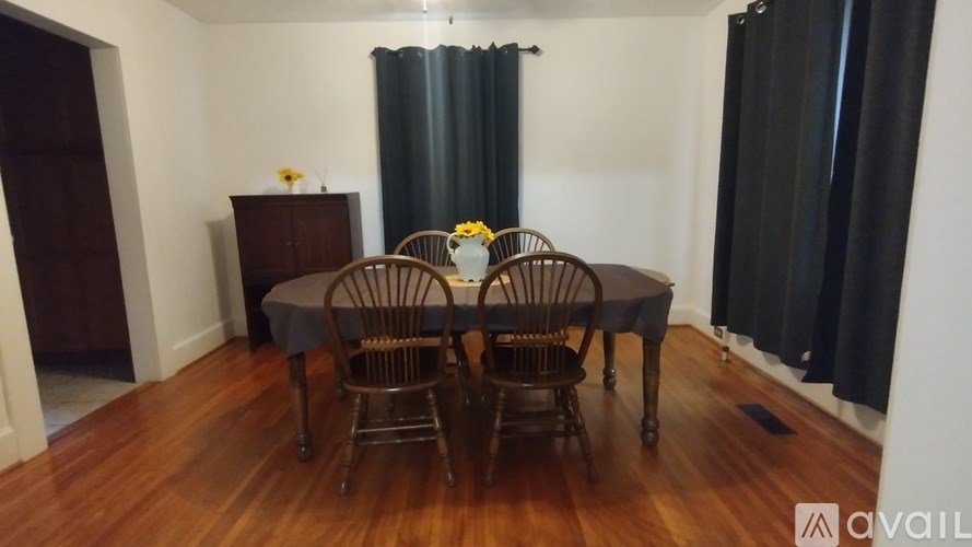 A room with wooden flooring and a wall with a doorway cut out.