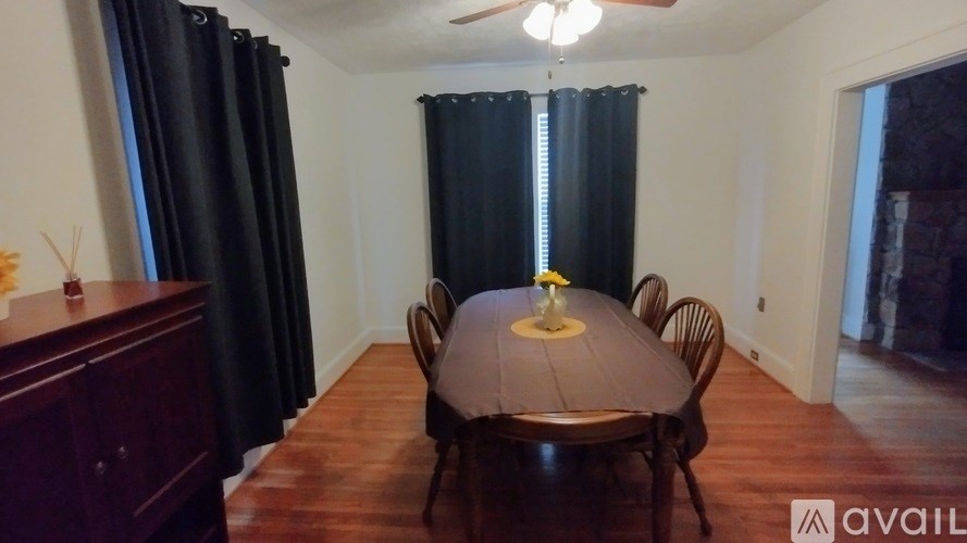 A room with a ceiling fan and a bed with a white bedspread.