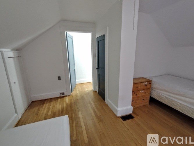 A bedroom with a bed, dresser, and wardrobe.