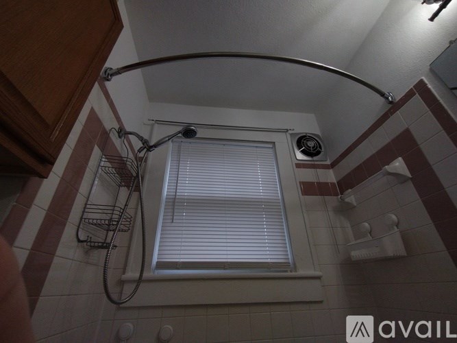 A bathroom with a shower curtain rod and a window.