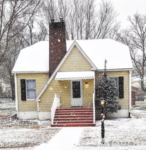 A small house with a red door and a red staircase.
