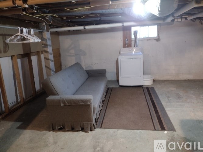 A room with a couch, a radiator, and a radiator cover.
