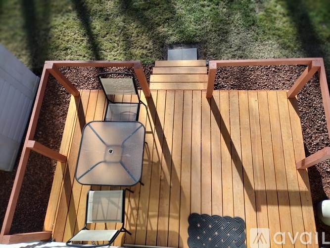 A wooden deck with a table and chairs.