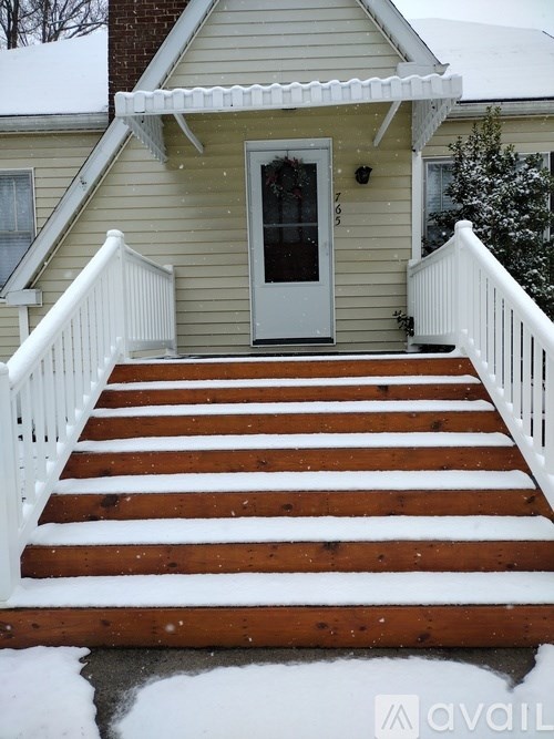 A house with a white door and a snow-covered staircase.