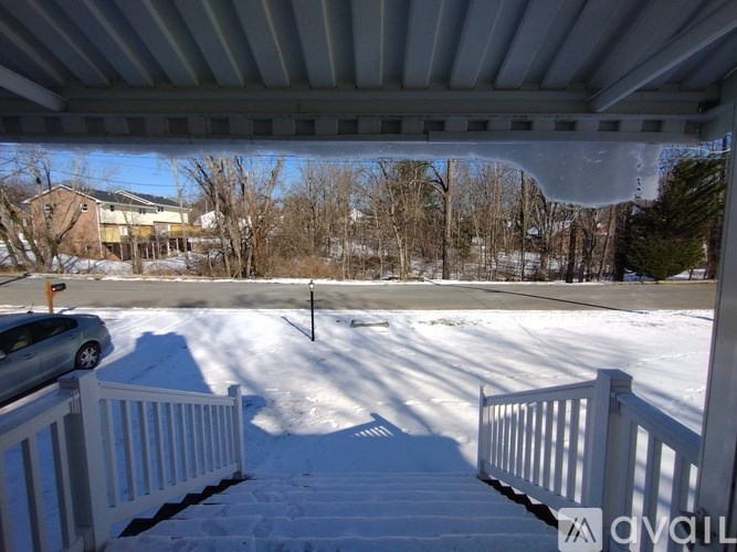 A snow-covered ground with a white fence and a pole in the middle.
