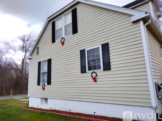 A house with a red wreath on the front door.