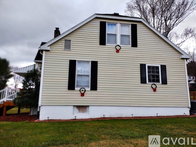 A house with a white front and black shutters is for sale.