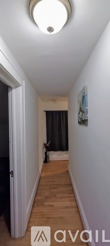 A bedroom with a bed, a small table, and a ceiling fan.