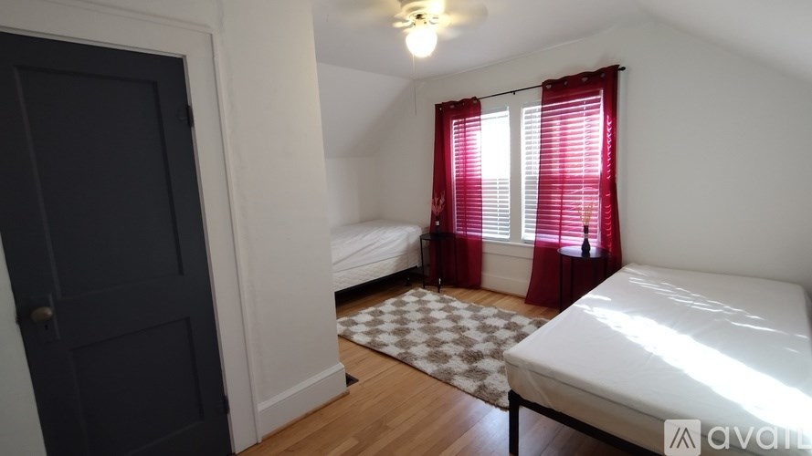 A bedroom with a bed, a table, and a vase of flowers.