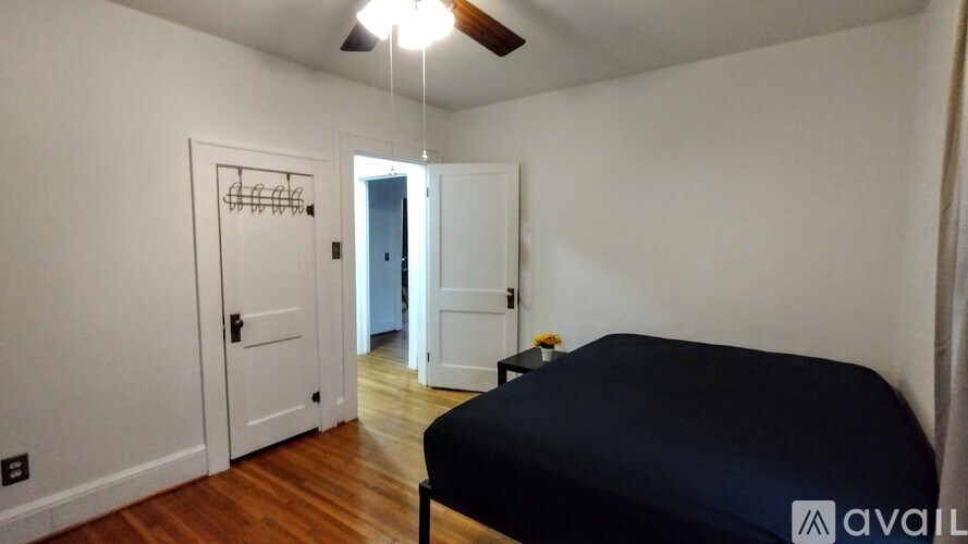 A bedroom with a bed, a closet, and a door leading to another room.