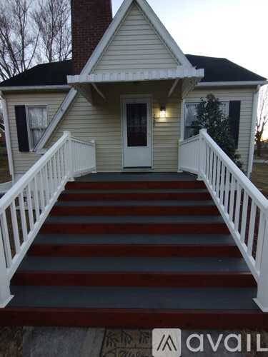 A house with a white front porch and red stairs.