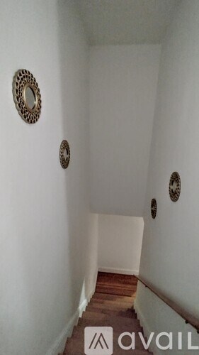 A hallway with three mirrors on the wall.